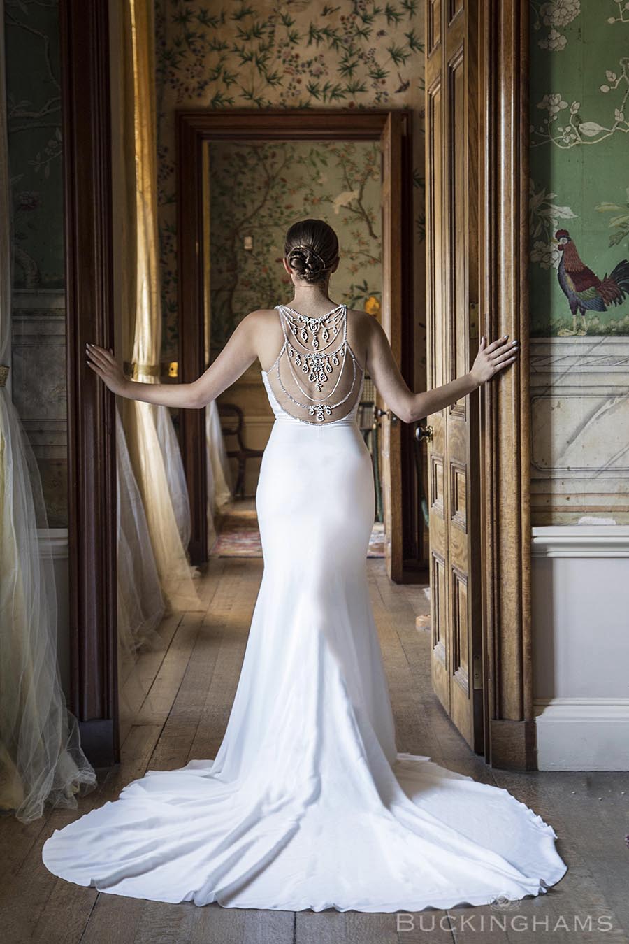 Image of bride facing away from the camera, stood in the doorway of one of the state rooms 
